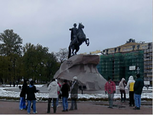 people looking at statue of man on horse